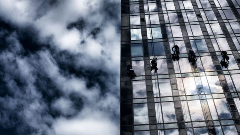 professional window cleaner working on modern house