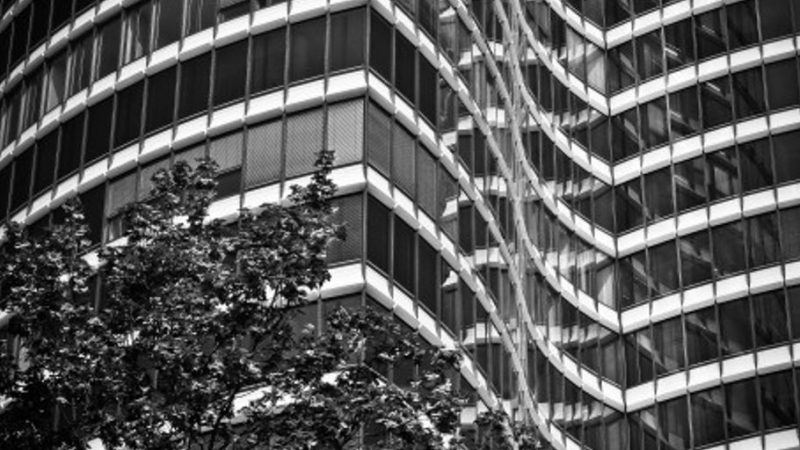 professional window cleaner working on skyscraper with cityscape background