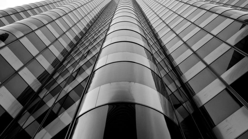 professional window cleaner working on high-rise building with cityscape in background