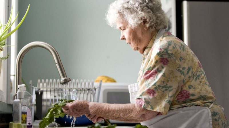 person cleaning home windows sunny day